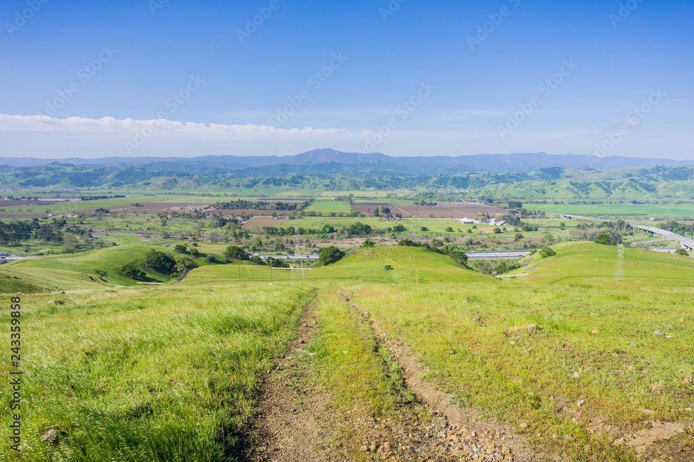 Hiking trail descending into the valley; Aerial view of agricultural fields and mountains in the  background, south San Francisco bay, San Jose, California