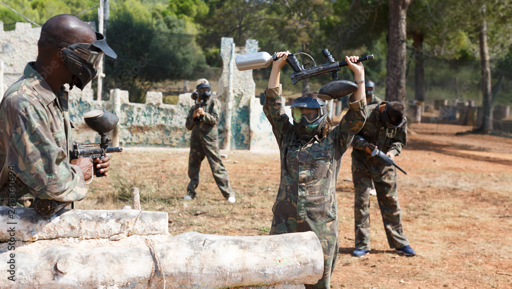 Fototapeta premium Woman playing paintball outdoors