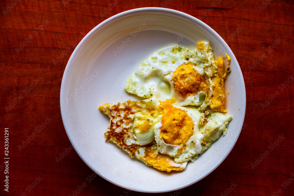 Healthy organic egg breakfast in a white bowl dish on a dark wood table Healthy organic egg breakfast in a white bowl dish on a dark wood table