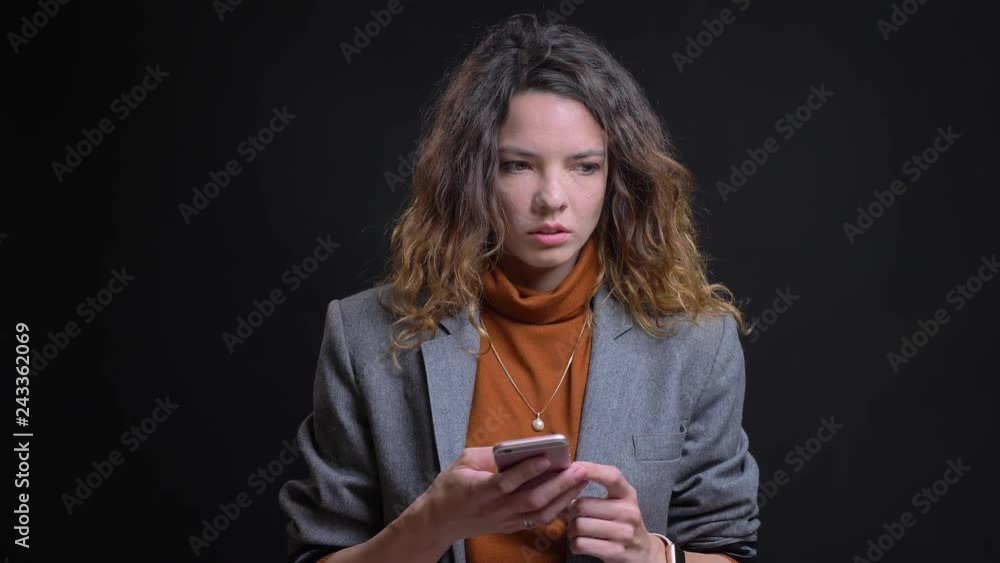Closeup portrait of modern attractive caucasian female typing on the phone and being thoughtful Closeup portrait of modern attractive caucasian female typing on the phone and being thoughtful