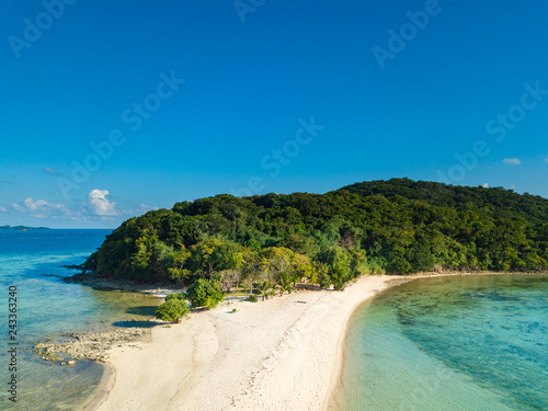 Aerial view of tropical beach on island Ditaytayan. Beautiful tropical island with white sandy beach, palm trees and green hills. Travel tropical concept. Palawan, Philippines