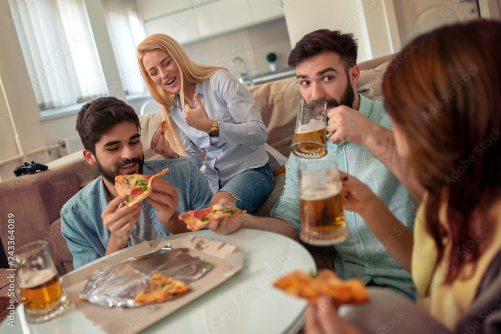 Group of happy young people eating pizza