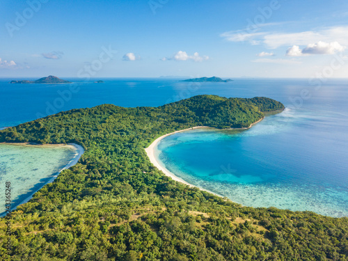 Aerial view of tropical beach on island Ditaytayan. Beautiful tropical island with white sandy beach, palm trees and green hills. Travel tropical concept. Palawan, Philippines