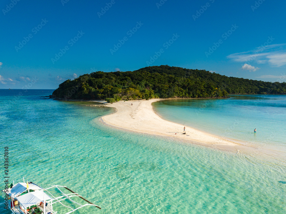 Aerial view of tropical  beach on island Ditaytayan. Beautiful tropical island with white sandy beach, palm trees and green hills. Travel tropical concept. Palawan, Philippines