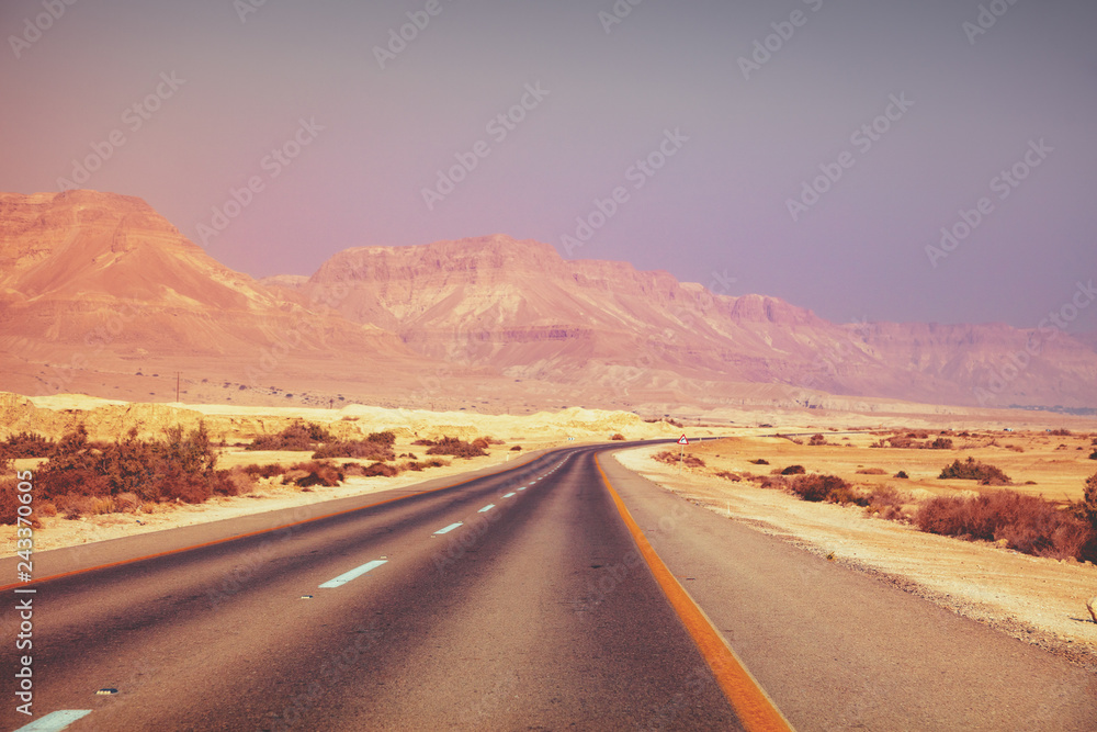Driving a car in the desert in the early morning