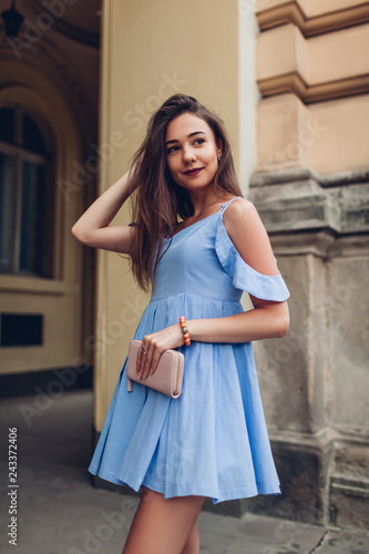 Outdoor portrait of young beautiful woman wearing stylish spring outfit and holding purse. Fashion, beauty model