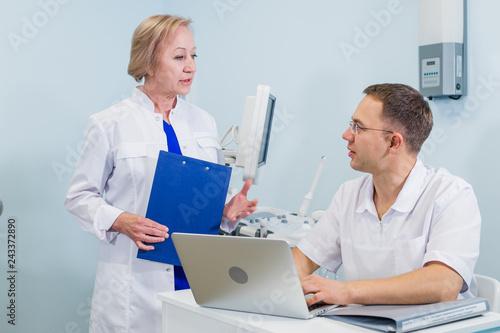 Doctor having conversation with his colleague in medical office