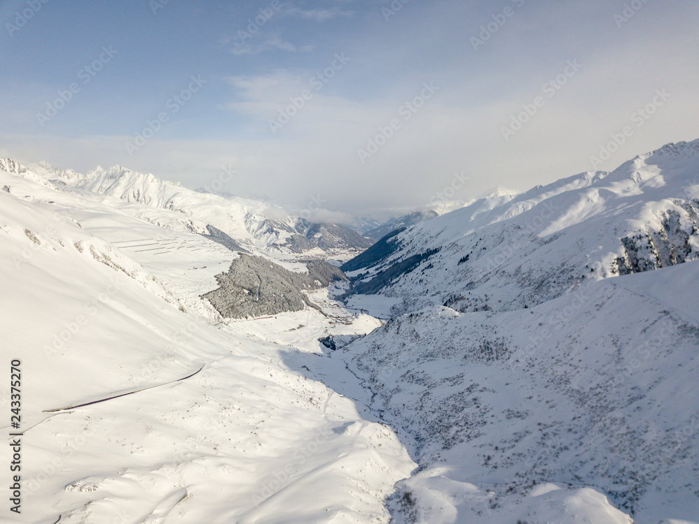Aerial view of snow covered mountains in Swiss alps. Beautiful panorama of wild and tranquil backcountry in alpine area.