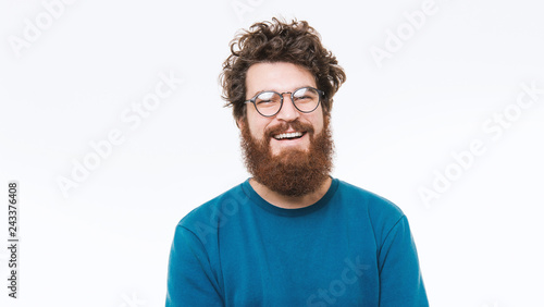 Portrait of smart  bearded man in blue sweater looking at camera and smiling