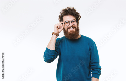 Stylish hispter in blue pullover with glasses, posing and looking at camera