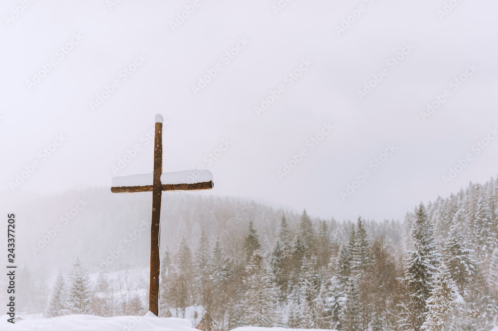 Picture of a cross in winter season, on winter mountains backgorund Picture of a cross in winter season, on winter mountains backgorund