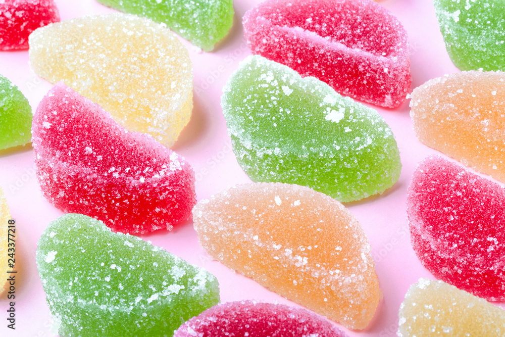colored fruit jelly with sugar crystals, on a pink background colored fruit jelly with sugar crystals, on a pink background