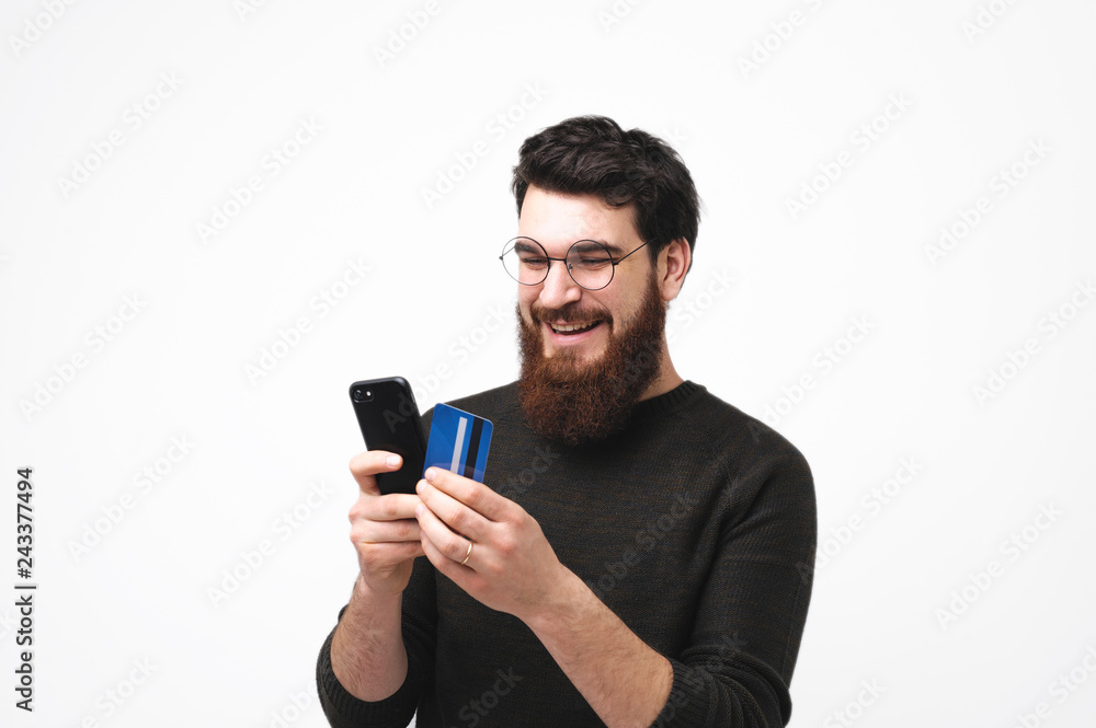 Happy smiling hipster guy is shopping oline Happy smiling hipster guy is shopping oline