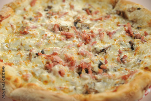 Pizza with ham, mushrooms and chees. Pizza occupies the entire frame space. View from above. Close-up. Macro shooting.