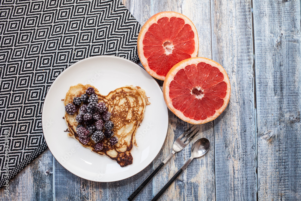 Hearts pancakes with blackberries on a white plate. wooden Background with grapefruit. Romantic or healthy breakfast Hearts pancakes with blackberries on a white plate. wooden Background with grapefruit. Romantic or healthy breakfast