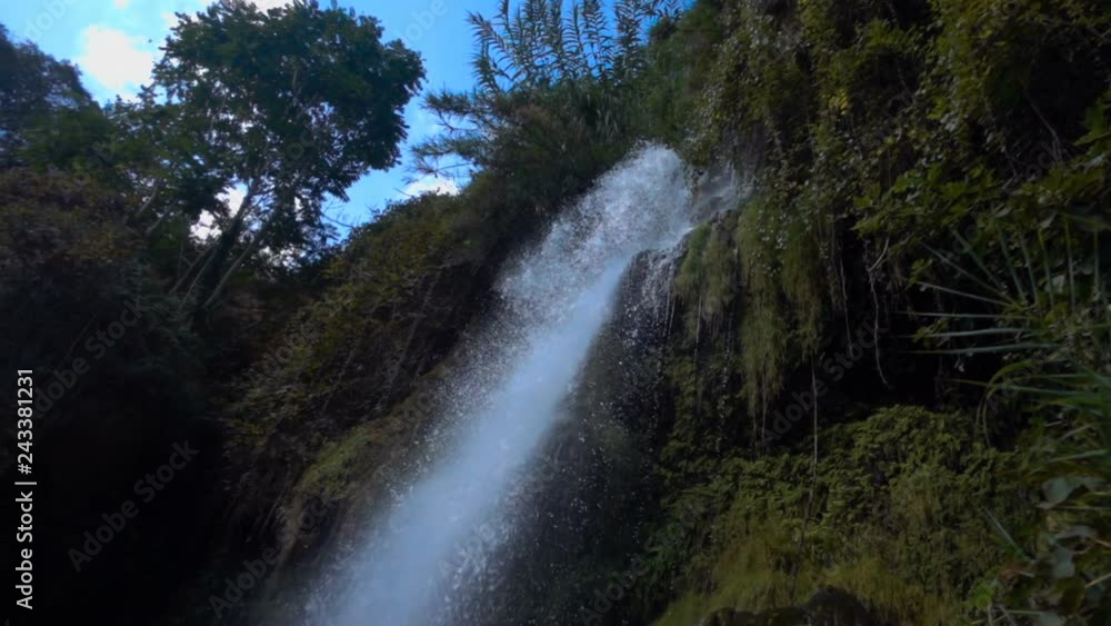 In the mountains among the green trees there is a high beautiful waterfall. Water from a great height hits the stones, breaking into the water dust. Slow mo, slo mo, slow motion, high speed camera, In the mountains among the green trees there is a high beautiful waterfall. Water from a great height hits the stones, breaking into the water dust. Slow mo, slo mo, slow motion, high speed camera,