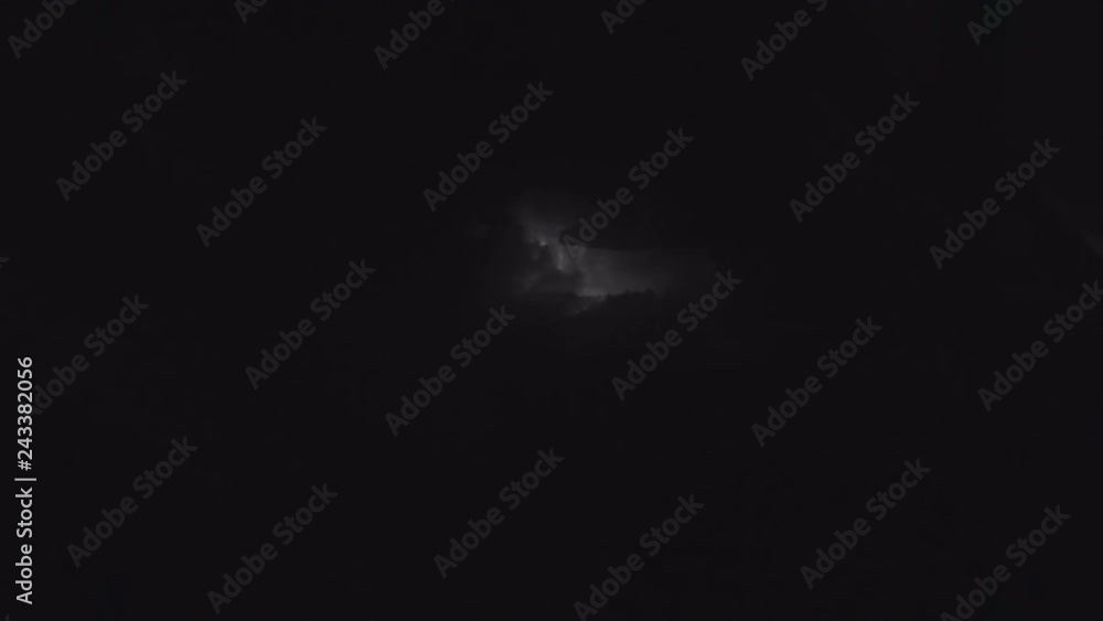 A strong night thunderstorm with lightning illuminating the clouds around. View from the porthole of the aircraft, flashing pulse airborne navigation light A strong night thunderstorm with lightning illuminating the clouds around. View from the porthole of the aircraft, flashing pulse airborne navigation light