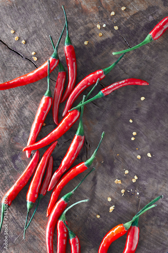 Close-up on red hot chili peppers on rustic wood, flat lay