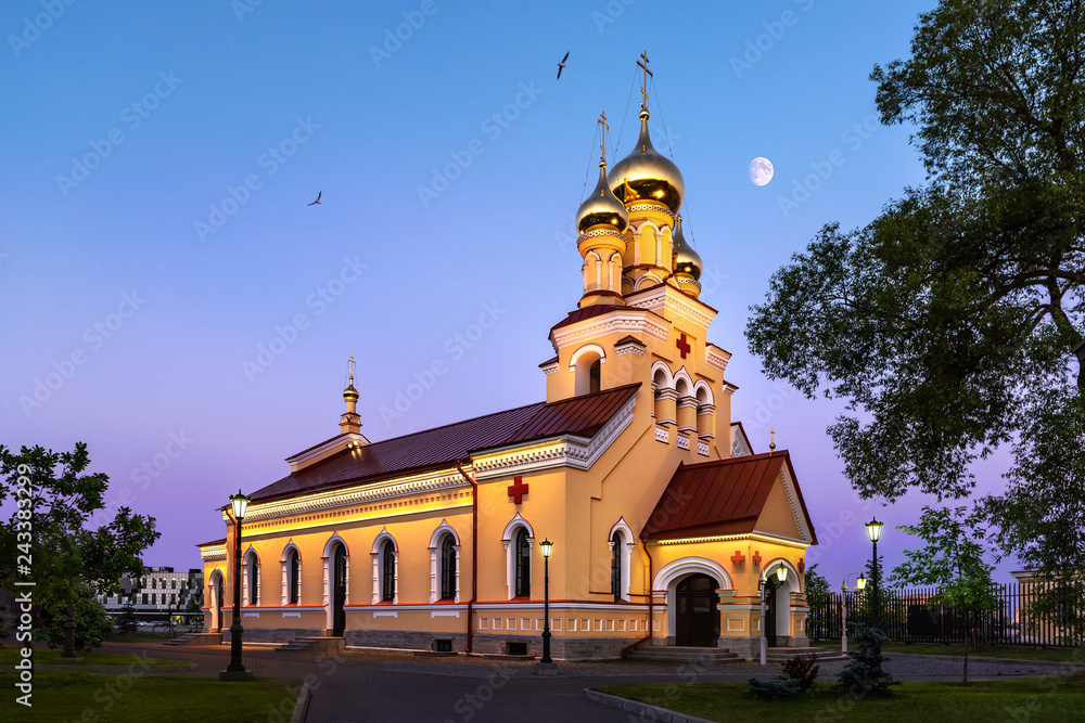 church with illumination and sunset moon in russia