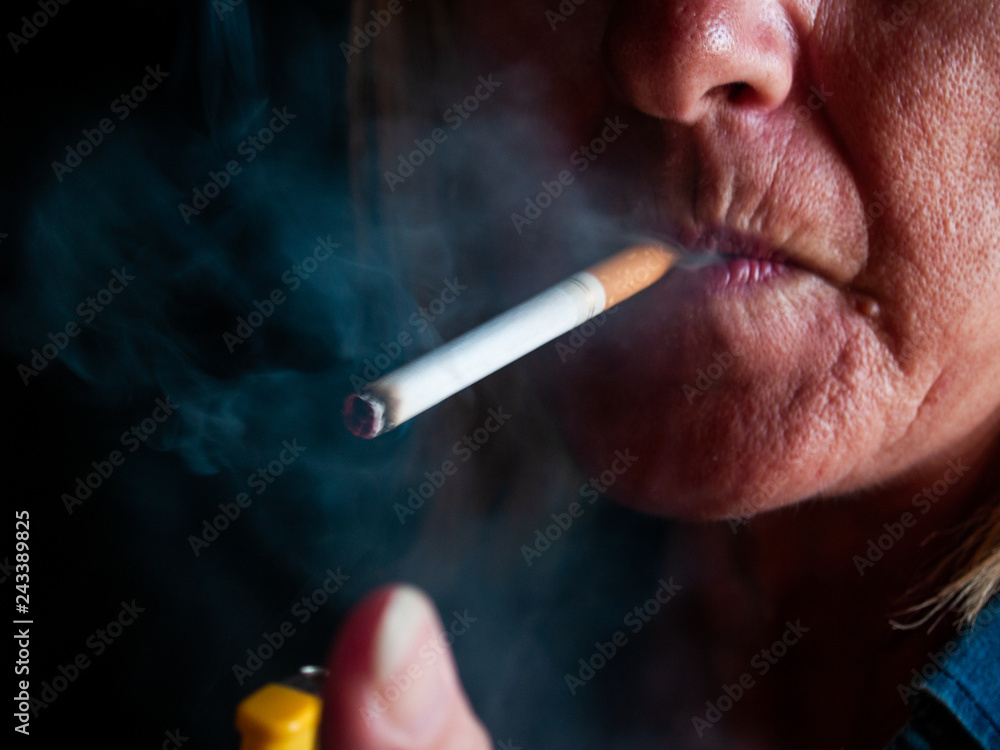 Fototapeta premium A mature woman smoking a cigarette
