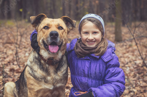 Portrait of a little girl and a big dog in the forest. Dog breed mastiff