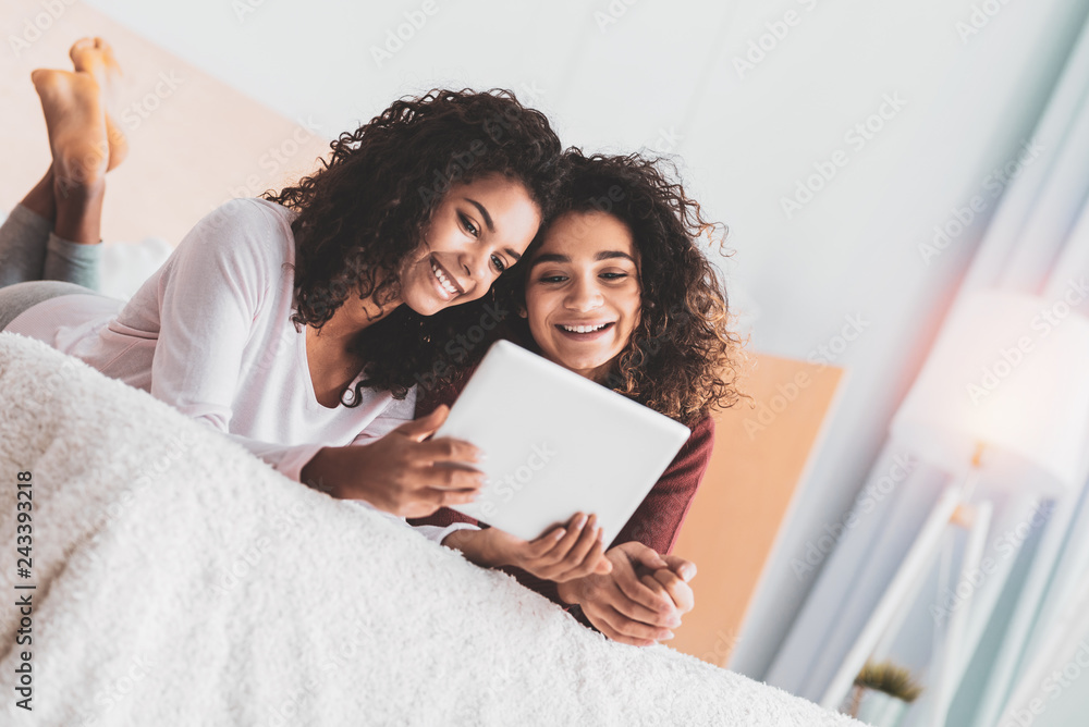 Two sisters lying on big spacious double bed Two sisters lying on big spacious double bed