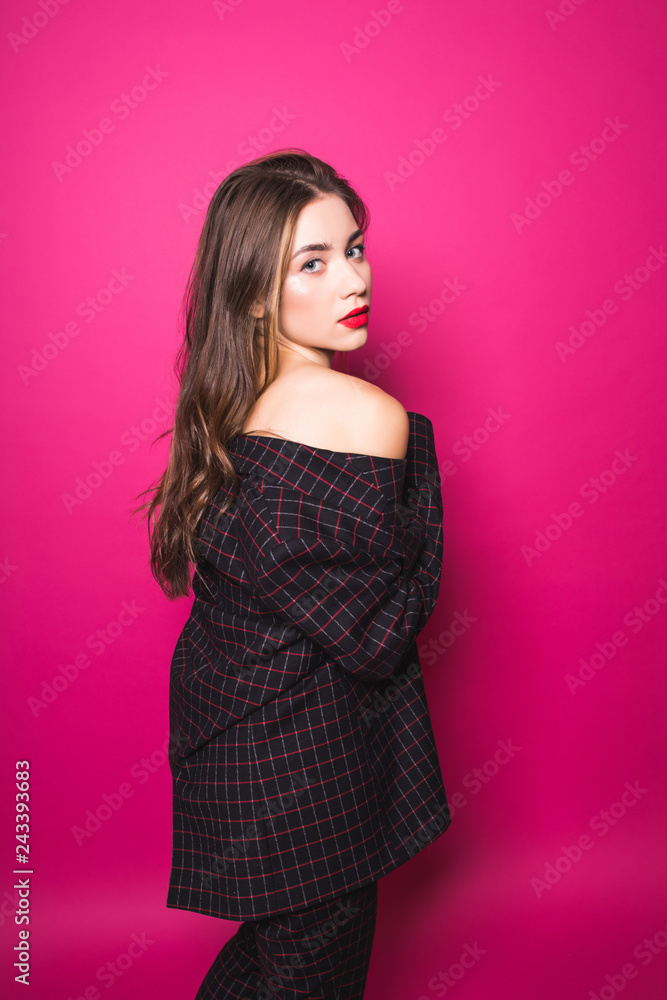 Portrait of charming pretty young woman clothed in suit dresses with naked shoulders, isolated on pink background Portrait of charming pretty young woman clothed in suit dresses with naked shoulders, isolated on pink background