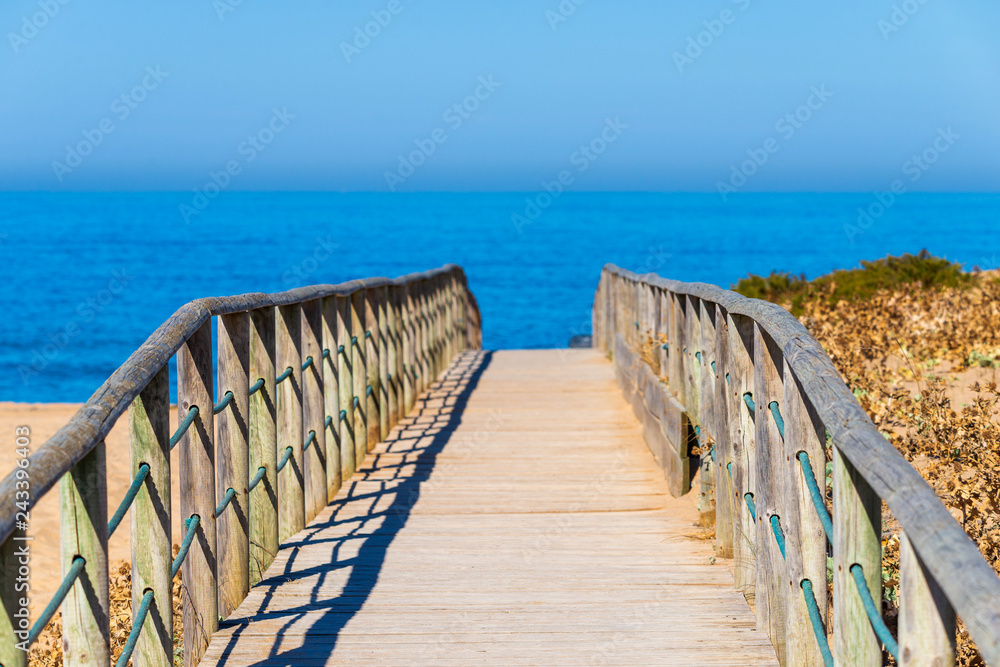 Obraz premium Wooden path on sand to sea. Vacation and rest on a beach concept