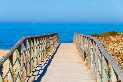 Wooden path on sand to sea. Vacation and rest on a beach concept