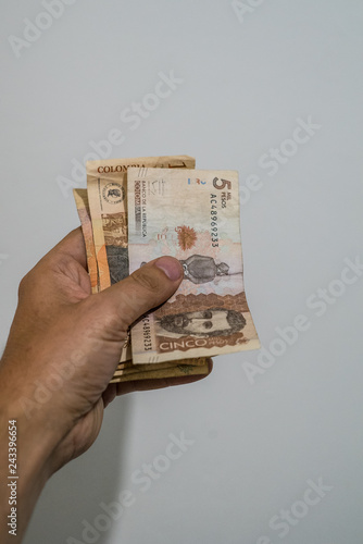 hand holding colombian banknotes of thousands of pesos, different cash value