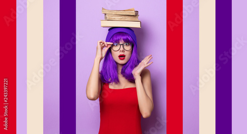 Portrait of young style hipster girl with purple hair and books on purple color background