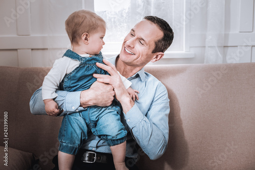 Nice positive man spending time together with his child