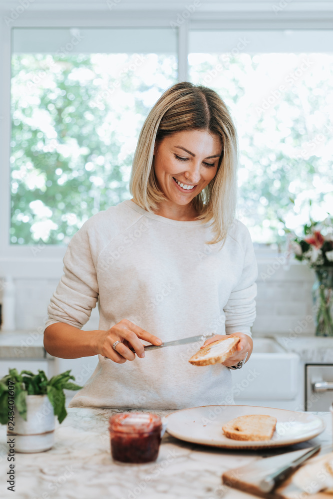 Woman spreading vegan cream cheese on a toast Woman spreading vegan cream cheese on a toast