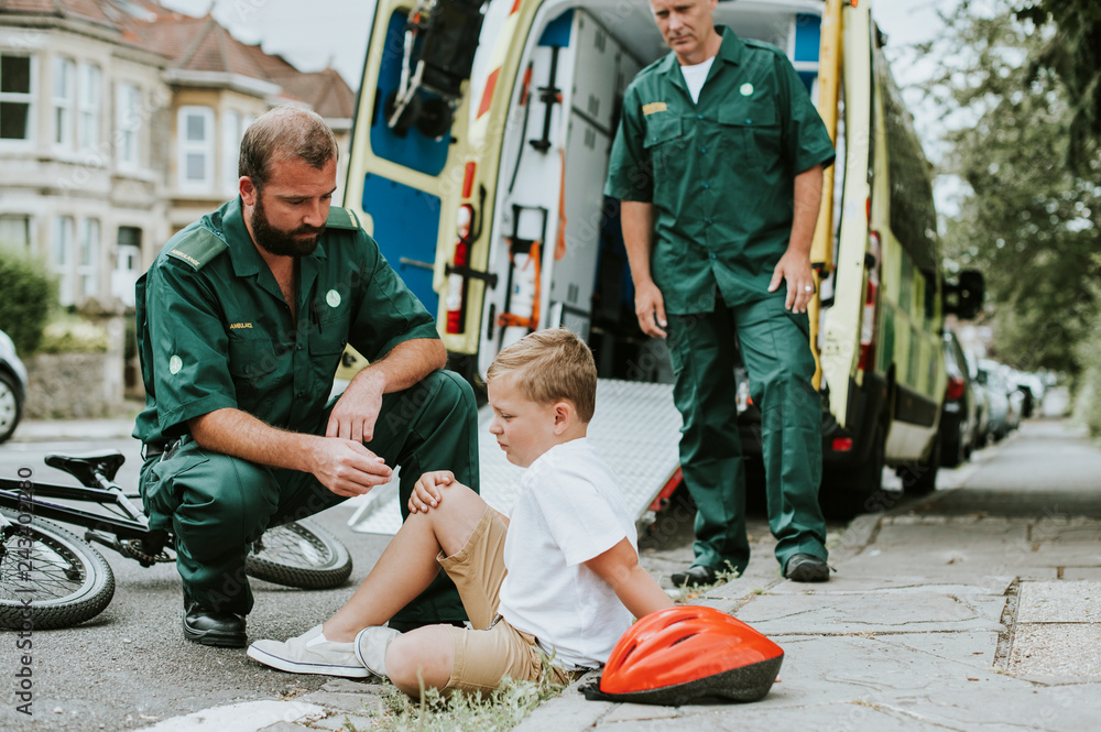 Injured boy getting help from paramedics Injured boy getting help from paramedics