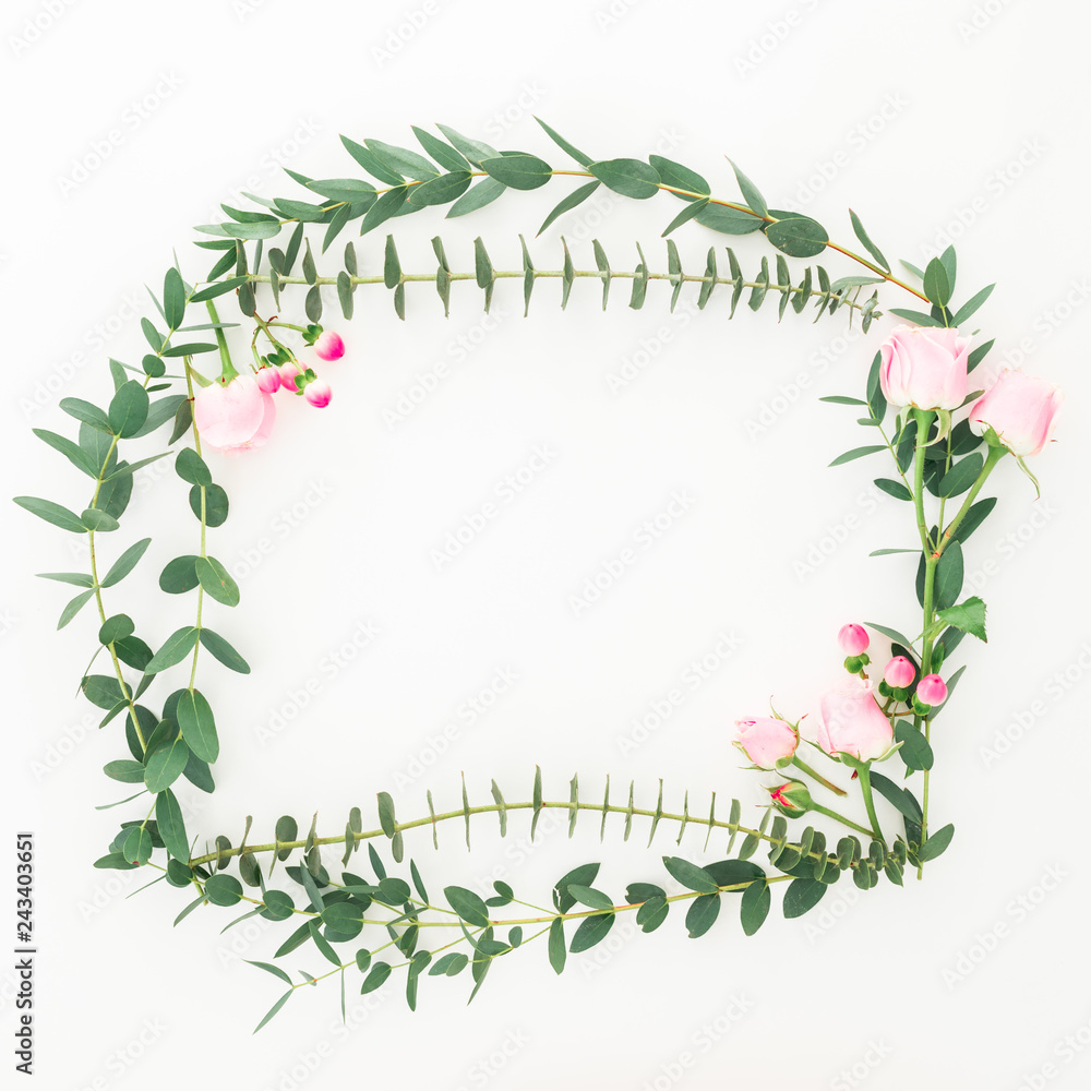 Flower frame of pink roses flowers and eucalyptus branches on white background. Flat lay, top view Flower frame of pink roses flowers and eucalyptus branches on white background. Flat lay, top view
