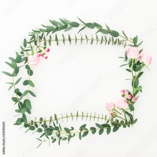 Flower frame of pink roses flowers and eucalyptus branches on white background. Flat lay, top view