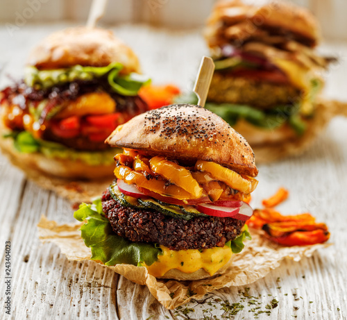 Veggie burgers, homemade vegan burger with fresh and grilled vegetables and aromatic curry sauce on a white rustic table. Conception of a healthy diet, healthy alternative