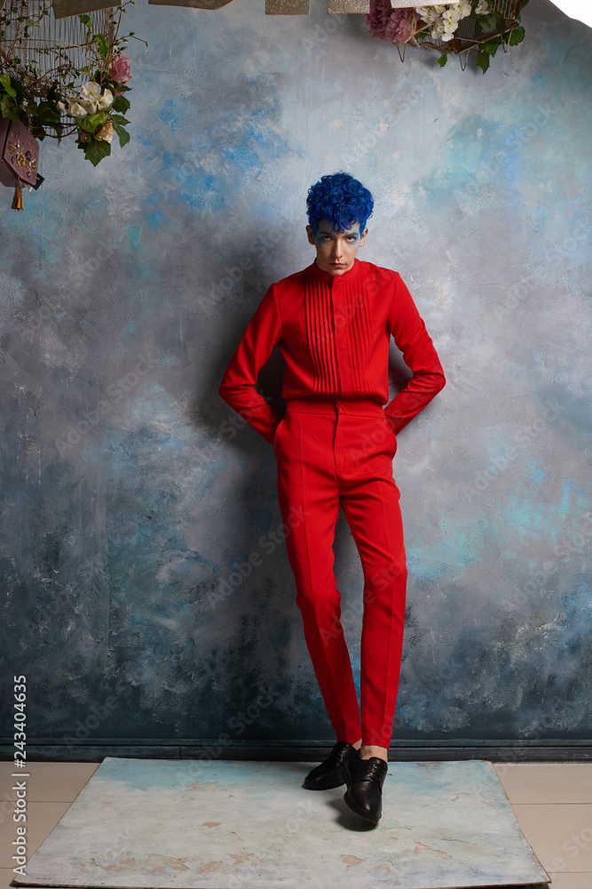 Obraz premium Portrait of a fashionable young guy in a tap-suit and a colorful blue hairstyle