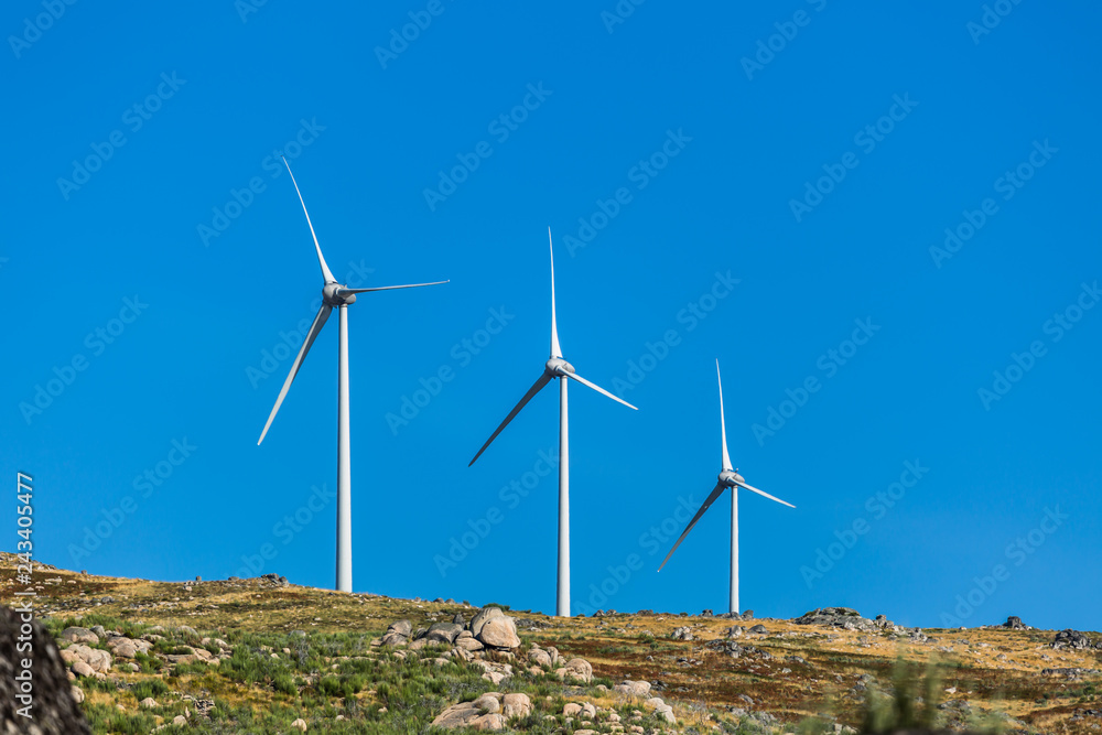 View of a wind turbines on top of mountains View of a wind turbines on top of mountains
