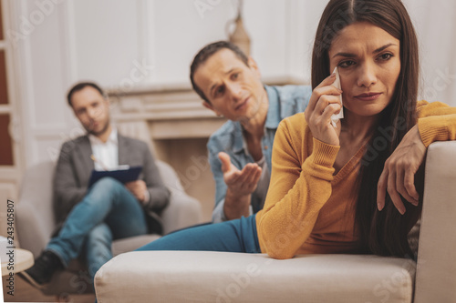 Dark-haired woman wearing yellow shirt crying during psychologist visit