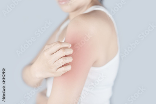 Woman scratching arm from itching on white background. Cause of itchy skin include insect bites, dermatitis, food/drugs allergies or dry skin. Concept of health care skin. photo