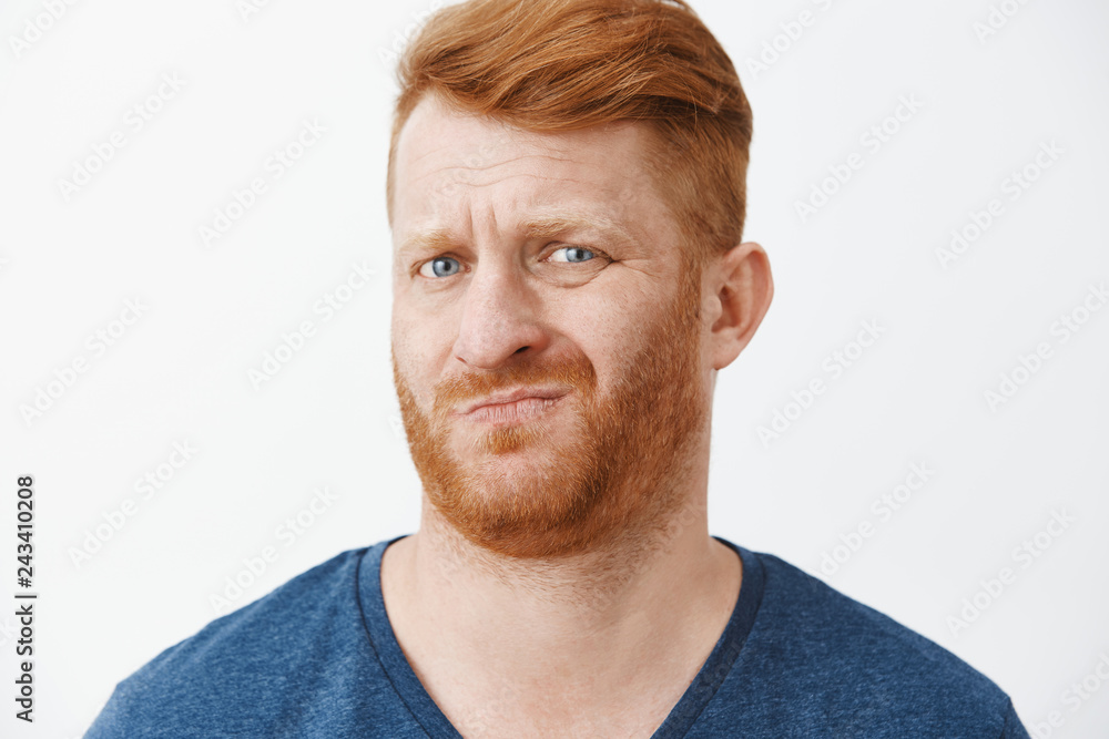 Sounds suspicious and gross. Portrait of unsure displeased funny redhead with cool hairstyle, frowning, smirking and wrinkling nose from dislike, looking doubtful at new meal wife made Sounds suspicious and gross. Portrait of unsure displeased funny redhead with cool hairstyle, frowning, smirking and wrinkling nose from dislike, looking doubtful at new meal wife made