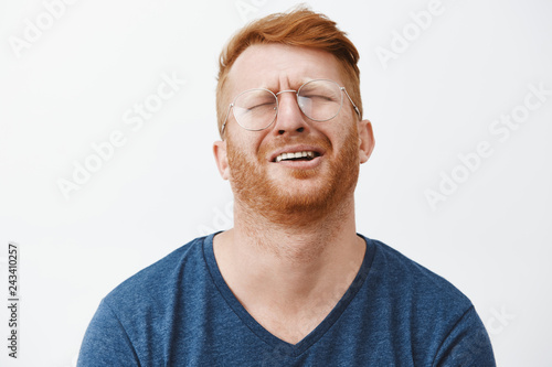 Indoor shot of gloomy and upset redhead mature man with beard, tilting head behind, frowning and grimacing, complaining to friend on bad life, whining or crying heart out in despair
