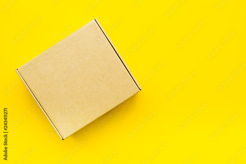 Delivery concept. Cardboard box on yellow background top view mockup Delivery concept. Cardboard box on yellow background top view mockup