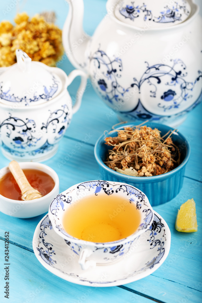 Cup of Linden Tea, Dried Linden Flowers in bowl with honey and lemon on wooden background Cup of Linden Tea, Dried Linden Flowers in bowl with honey and lemon on wooden background