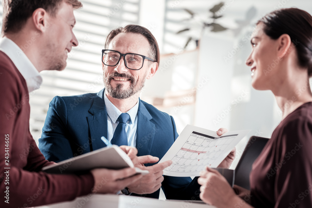 Cheerful three colleagues deciding on conference date Cheerful three colleagues deciding on conference date