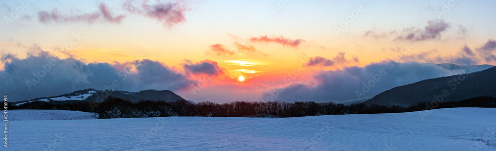 Panoramic view to beautiful vibrant winter sunset in the mountains Panoramic view to beautiful vibrant winter sunset in the mountains