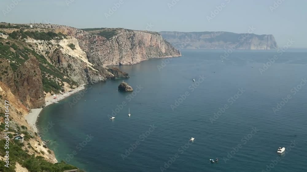 Sea distance in a misty haze view from the mountains. Yachts are sailing along the coastline Sea distance in a misty haze view from the mountains. Yachts are sailing along the coastline