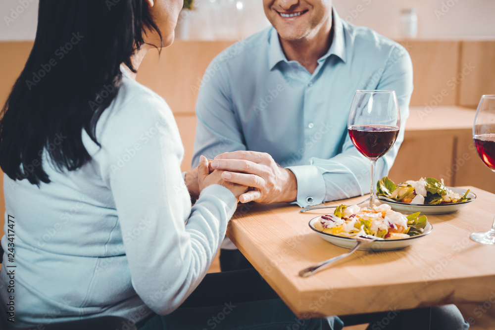 Brunette woman holding a hand of a man Brunette woman holding a hand of a man