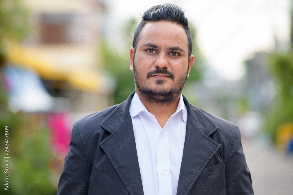 Face of bearded Indian businessman wearing suit outdoors Face of bearded Indian businessman wearing suit outdoors